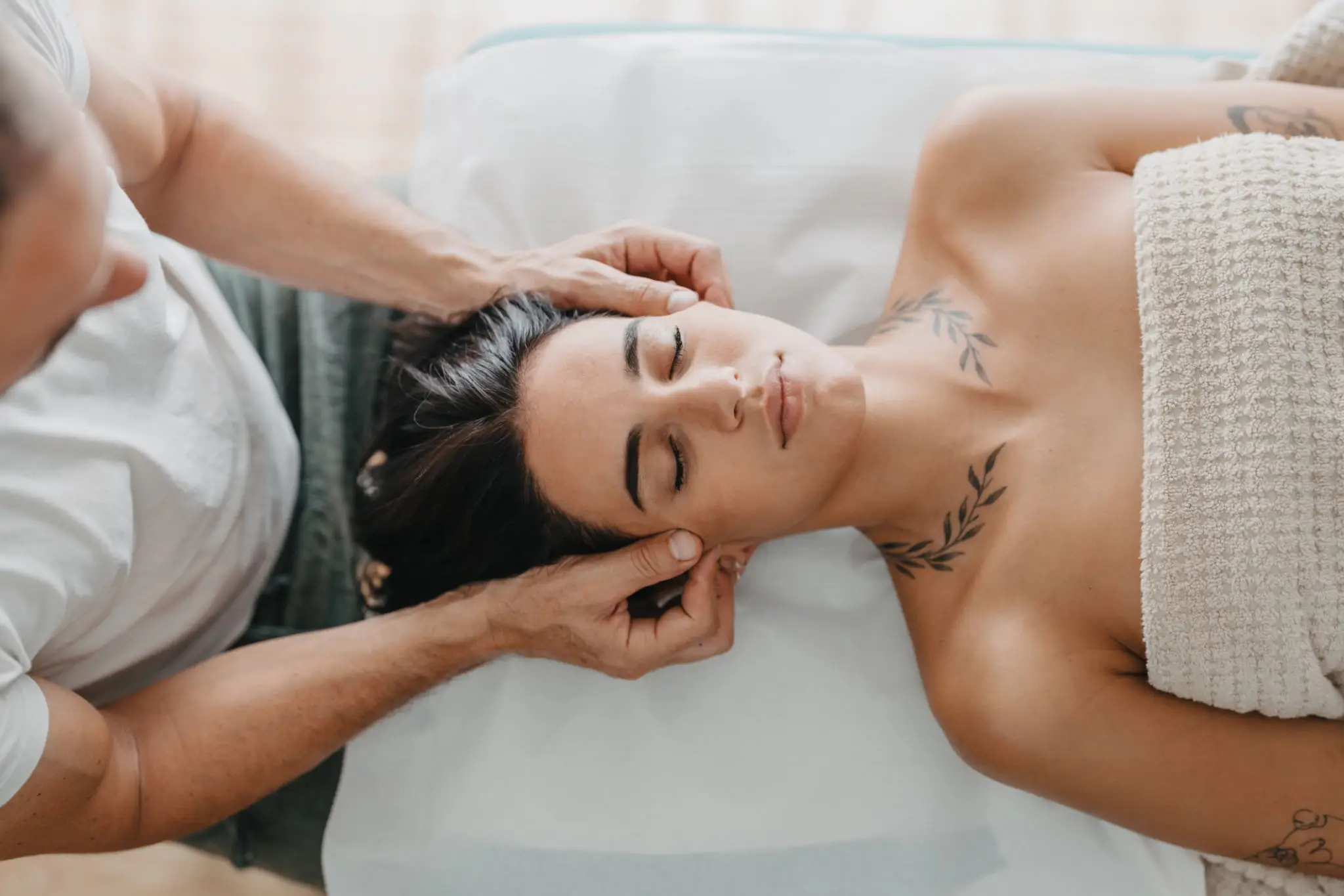 A woman receiving a relaxing head massage at a spa.