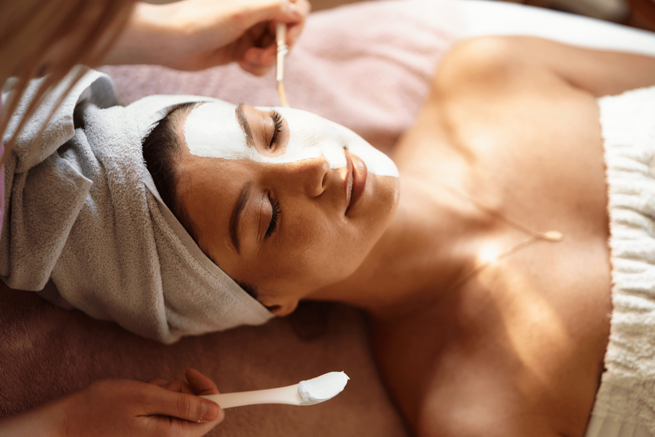 Woman enjoying a relaxing facial treatment at a spa.