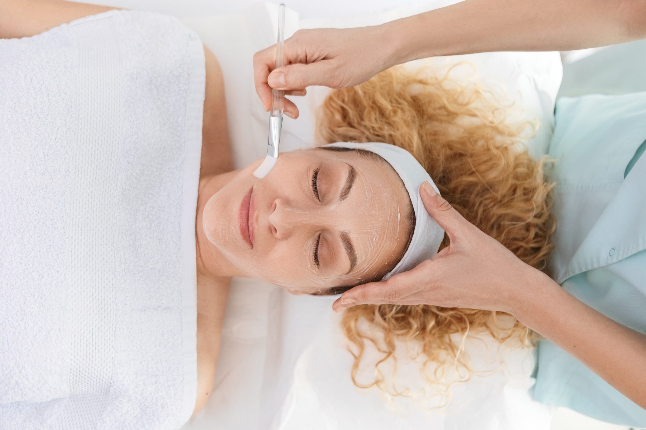 Woman enjoying a relaxing facial massage at a spa.