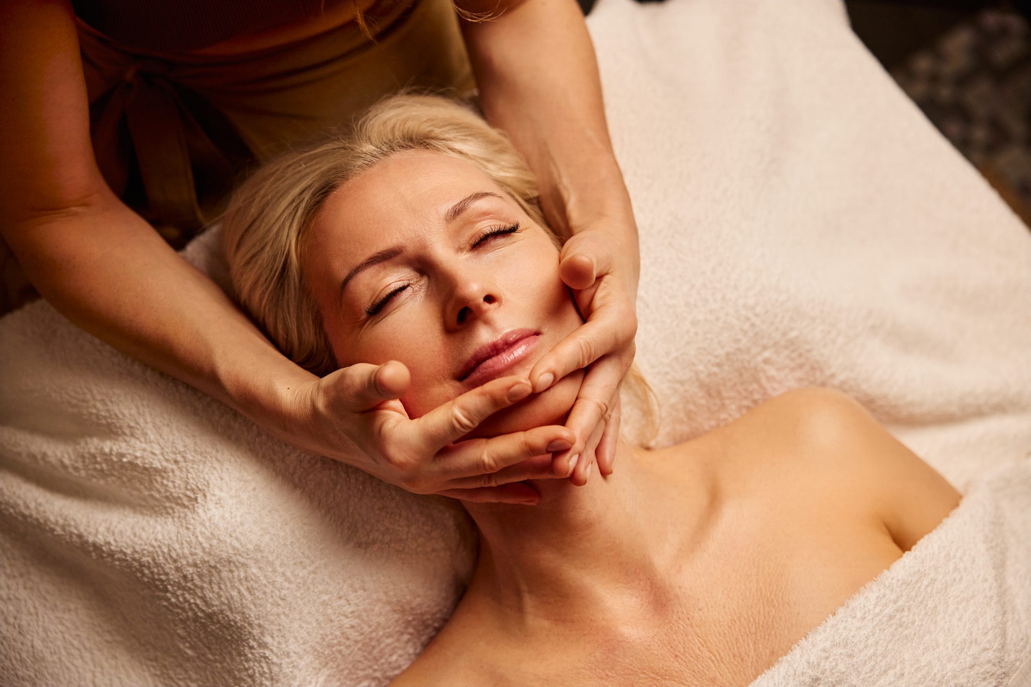 Woman enjoying a relaxing facial massage at a spa.
