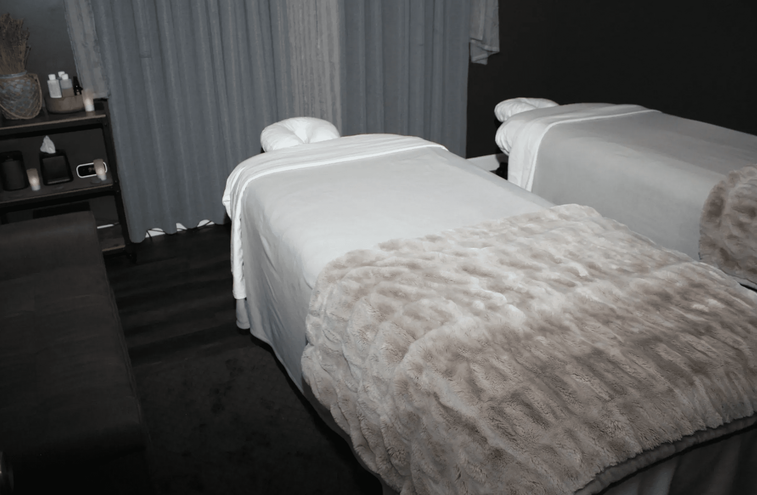 A cozy spa bed with a soft, furry blanket in a dimly lit room.